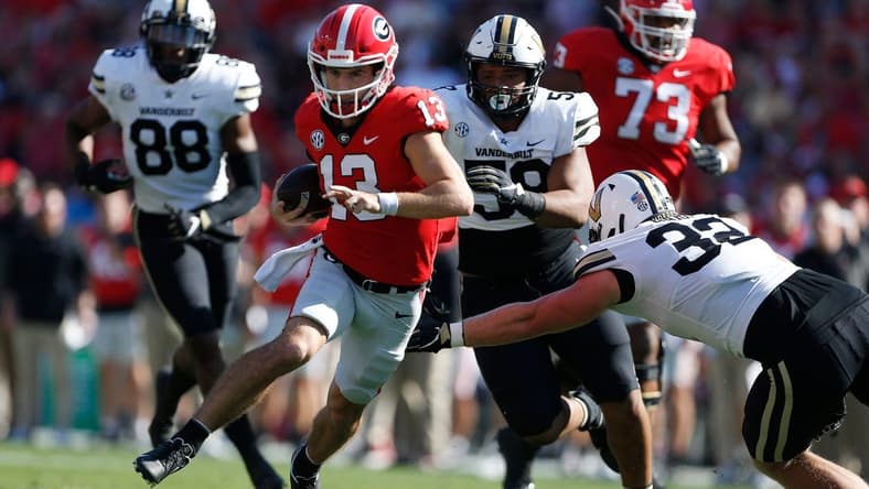 Georgia quarterback Stetson Bennett (13) avoids a tackle from Vanderbilt linebacker Ethan Barr (32) during the 1st half as Georgia takes on Vanderbilt at Sanford Stadium in Athens, Ga. on Saturday, Oct. 15th, 2022.

Sports Richard Hamm