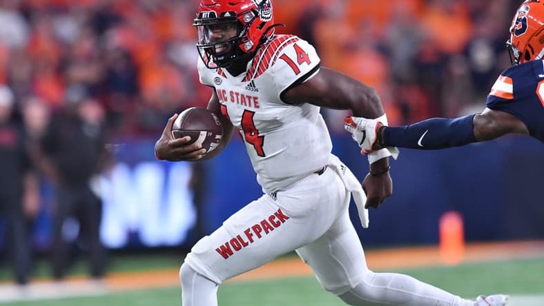 Oct 15, 2022; Syracuse, New York, USA; North Carolina State Wolfpack quarterback Jack Chambers (14) runs for a first down against the Syracuse Orange in the fourth quarter at JMA Wireless Dome. Mandatory Credit: Mark Konezny-USA TODAY Sports