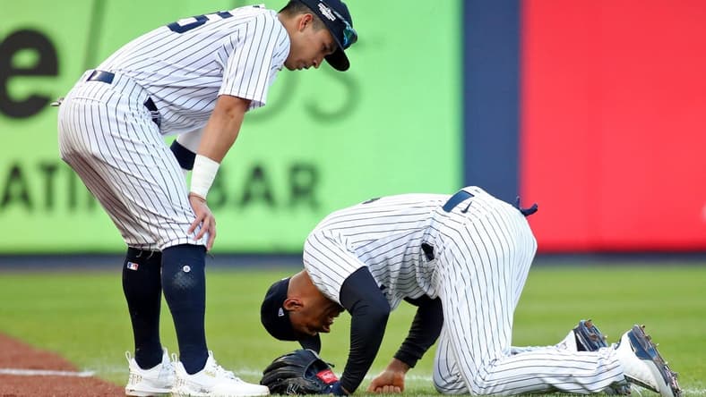 Oct 18, 2022; Bronx, New York, USA; New York Yankees left fielder Aaron Hicks (right) reacts after colliding with shortstop Oswaldo Cabrera (left) while trying to catch a ball hit by Cleveland Guardians left fielder Steven Kwan (not pictured) for a single against the Cleveland Guardians during the third inning in game five of the ALDS for the 2022 MLB Playoffs at Yankee Stadium. Mandatory Credit: Wendell Cruz-USA TODAY Sports