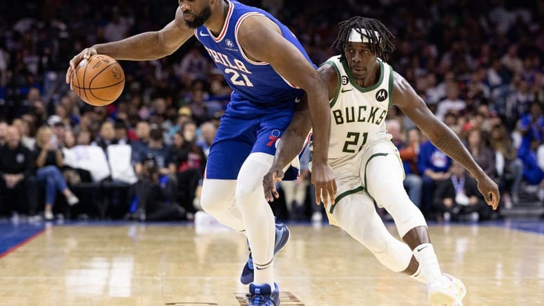 Oct 20, 2022; Philadelphia, Pennsylvania, USA; Philadelphia 76ers center Joel Embiid (21) is tripped up and fouled by Milwaukee Bucks guard Jrue Holiday (21) during the second quarter at Wells Fargo Center. Mandatory Credit: Bill Streicher-USA TODAY Sports