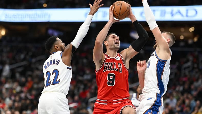 Oct 21, 2022; Washington, District of Columbia, USA; Chicago Bulls center Nikola Vucevic (9) shoots in-between Washington Wizards guard Monte Morris (22) and center Kristaps Porzingis (6) during the second half at Capital One Arena. Mandatory Credit: Tommy Gilligan-USA TODAY Sports