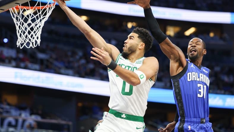 Oct 22, 2022; Orlando, Florida, USA; Boston Celtics forward Jayson Tatum (0) shoots the ball over Orlando Magic guard Terrence Ross (31) in the first quarter at Amway Center. Mandatory Credit: Nathan Ray Seebeck-USA TODAY Sports