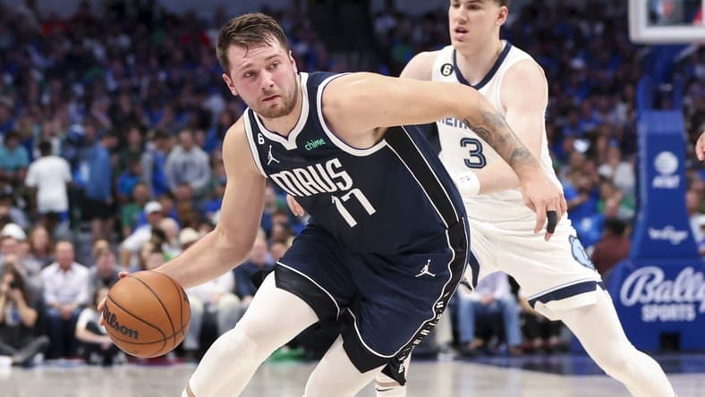 Oct 22, 2022; Dallas, Texas, USA; Dallas Mavericks guard Luka Doncic (77) controls the ball as Memphis Grizzlies forward Jake LaRavia (3) defends during the first quarter at American Airlines Center. Mandatory Credit: Kevin Jairaj-USA TODAY Sports