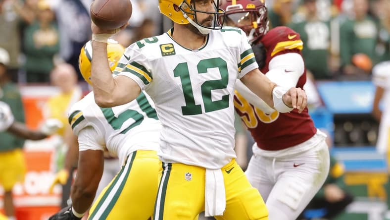Oct 23, 2022; Landover, Maryland, USA; Green Bay Packers quarterback Aaron Rodgers (12) passes the ball as Washington Commanders defensive end Montez Sweat (90) chases during the fourth quarter at FedExField. Mandatory Credit: Geoff Burke-USA TODAY Sports