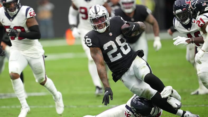 Oct 23, 2022; Paradise, Nevada, USA; Houston Texans safety Jonathan Owens (36) tackles Las Vegas Raiders running back Josh Jacobs (28) in the first half at Allegiant Stadium. Mandatory Credit: Stephen R. Sylvanie-USA TODAY Sports