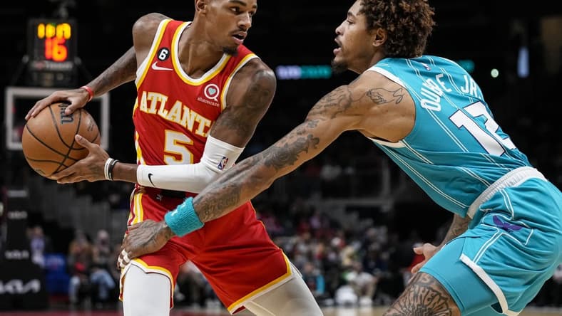 Oct 23, 2022; Atlanta, Georgia, USA; Atlanta Hawks guard Dejounte Murray (5) controls the ball against Charlotte Hornets guard Kelly Oubre Jr. (12) during the first half at State Farm Arena. Mandatory Credit: Dale Zanine-USA TODAY Sports