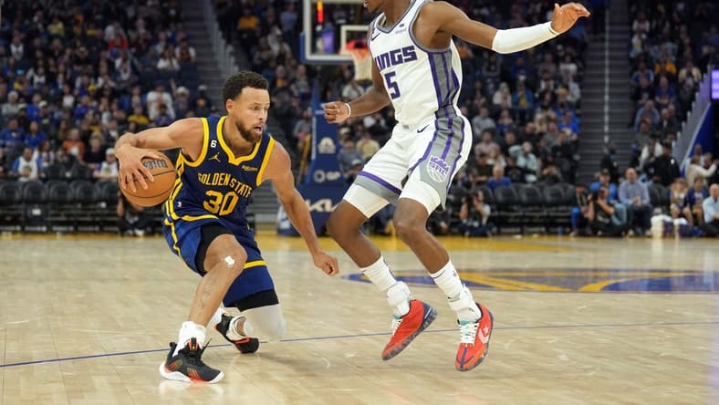 Oct 23, 2022; San Francisco, California, USA; Golden State Warriors guard Stephen Curry (30) dribbles against Sacramento Kings guard De'Aaron Fox (5) during the third quarter at Chase Center. Mandatory Credit: Darren Yamashita-USA TODAY Sports