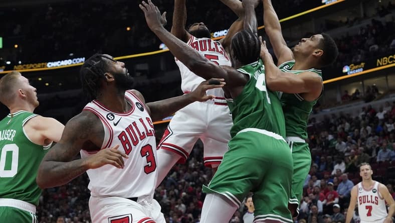 Oct 24, 2022; Chicago, Illinois, USA; Chicago Bulls forward Derrick Jones Jr. (5) goes up for a shot on Boston Celtics forward Noah Vonleh (4) during the first half at United Center. Mandatory Credit: David Banks-USA TODAY Sports