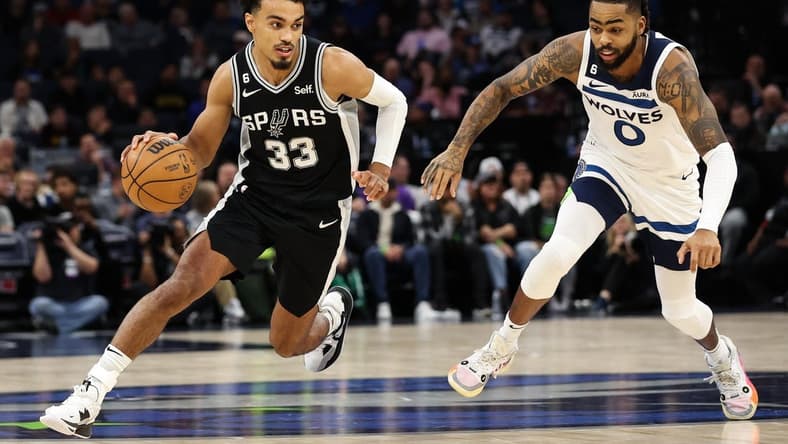 Oct 24, 2022; Minneapolis, Minnesota, USA; San Antonio Spurs guard Tre Jones (33) dribbles while Minnesota Timberwolves guard D'Angelo Russell (0) defends during the second quarter at Target Center. Mandatory Credit: Matt Krohn-USA TODAY Sports