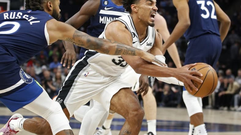 Oct 26, 2022; Minneapolis, Minnesota, USA; Minnesota Timberwolves guard D'Angelo Russell (0) fouls San Antonio Spurs guard Tre Jones (33) in the first quarter at Target Center. Mandatory Credit: Bruce Kluckhohn-USA TODAY Sports