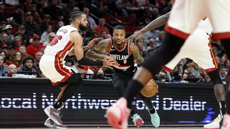 Oct 26, 2022; Portland, Oregon, USA; Portland Trail Blazers point guard Damian Lillard (0) dribbles the ball while defended by Miami Heat small forward Caleb Martin (16) during the first half at Moda Center. Mandatory Credit: Soobum Im-USA TODAY Sports