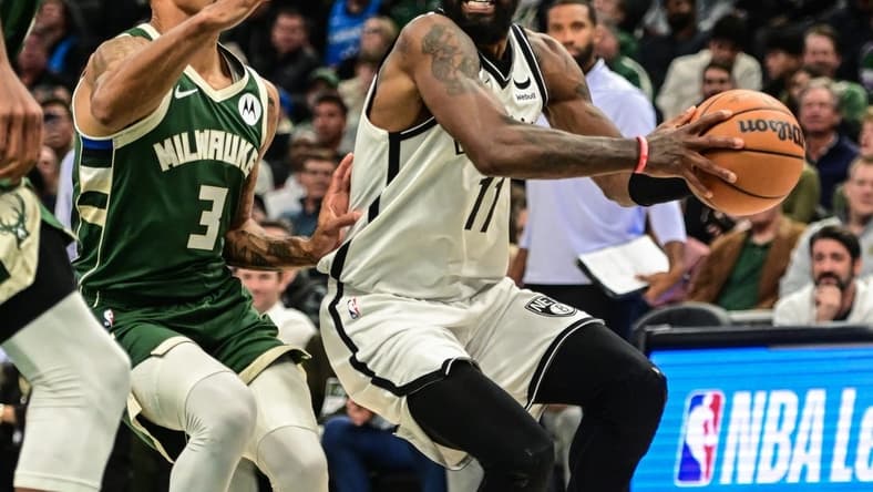 Oct 26, 2022; Milwaukee, Wisconsin, USA; Brooklyn Nets guard Kyrie Irving (11) drives to the basket against Milwaukee Bucks guard George Hill (3) in the fourth quarter at Fiserv Forum. Mandatory Credit: Benny Sieu-USA TODAY Sports