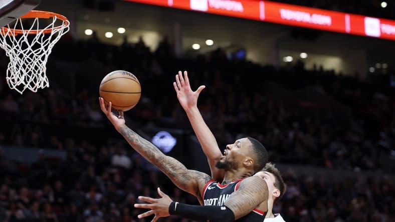 Oct 26, 2022; Portland, Oregon, USA; Portland Trail Blazers point guard Damian Lillard (0) drives to the basket past Miami Heat forward Nikola Jovic (5) during the first half at Moda Center. Mandatory Credit: Soobum Im-USA TODAY Sports
