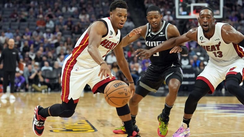 Oct 29, 2022; Sacramento, California, USA; Miami Heat guard Kyle Lowry (7) dribbles against Sacramento Kings guard De'Aaron Fox (5) as center Bam Adebayo (13) sets a screen during the second quarter at Golden 1 Center. Mandatory Credit: Darren Yamashita-USA TODAY Sports