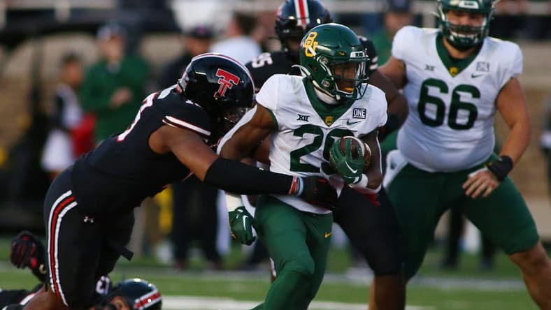 Oct 29, 2022; Lubbock, Texas, USA;  Baylor Bears running back Richard Reese (29) rushes against Texas Tech Red Raiders defensive linebacker Tyree Wilson (19) in the first half at Jones AT&T Stadium and Cody Campbell Field. Mandatory Credit: Michael C. Johnson-USA TODAY Sports