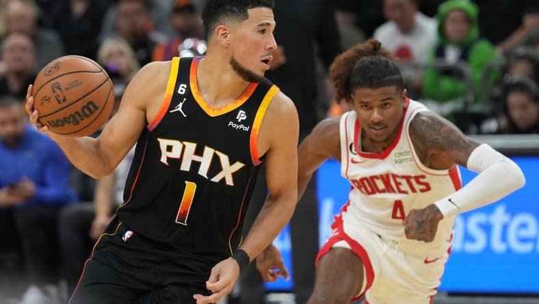 Oct 30, 2022; Phoenix, Arizona, USA; Phoenix Suns guard Devin Booker (1) dribbles against Houston Rockets guard Jalen Green (4) during the second half at Footprint Center. Mandatory Credit: Joe Camporeale-USA TODAY Sports