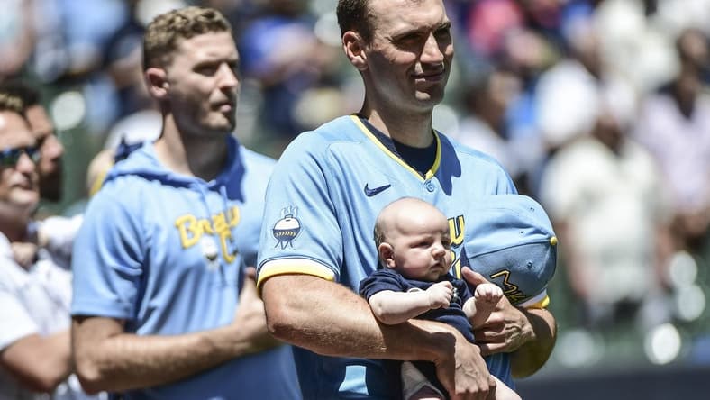 Jun 26, 2022; Milwaukee, Wisconsin, USA; Milwaukee Brewers pitcher Brent Suter (35) holds his baby during the National Anthem before game against Toronto Blue Jays at American Family Field. Mandatory Credit: Benny Sieu-USA TODAY Sports