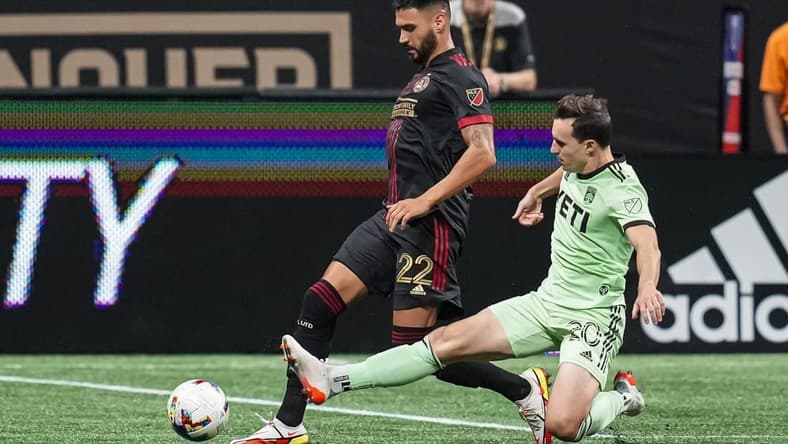 Jul 9, 2022; Atlanta, Georgia, USA; Austin FC midfielder Jared Stroud (20) kicks the ball away from Atlanta United defender Juan Jose Purata during the second half at Mercedes-Benz Stadium. Mandatory Credit: Dale Zanine-USA TODAY Sports