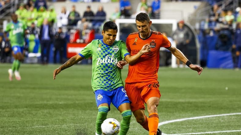 Sep 4, 2022; Seattle, Washington, USA; Houston Dynamo defender Daniel Steres (2) clears a ball in the box away from Seattle Sounders FC forward Raul Ruidiaz (9) during the second half at Lumen Field. Mandatory Credit: Joe Nicholson-USA TODAY Sports