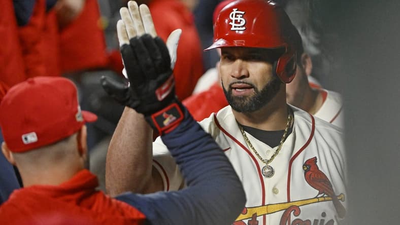 Oct 8, 2022; St. Louis, Missouri, USA; St. Louis Cardinals designated hitter Albert Pujols (5) is congratulated in the dugout following his single in the eighth inning against the Philadelphia Phillies during game two of the Wild Card series for the 2022 MLB Playoffs at Busch Stadium. Mandatory Credit: Jeff Curry-USA TODAY Sports