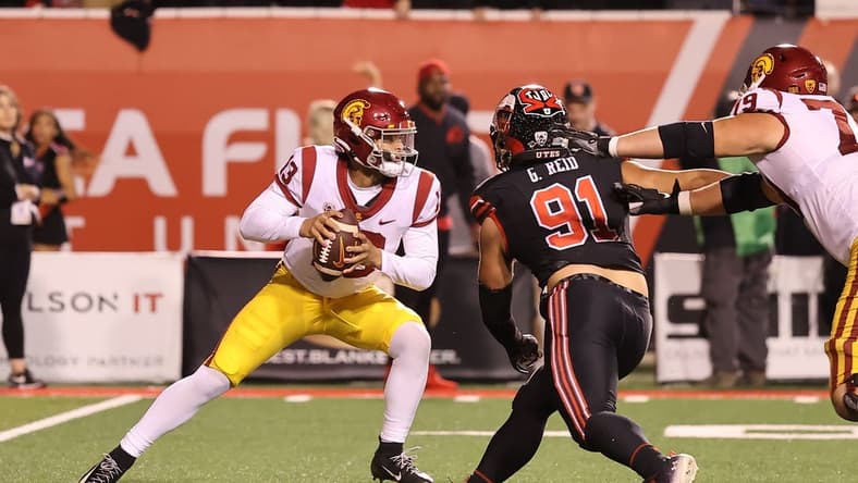 Oct 15, 2022; Salt Lake City, Utah, USA; USC Trojans quarterback Caleb Williams (13) scrambles away from the pressure of Utah Utes defensive end Gabe Reid (91) in the second quarter at Rice-Eccles Stadium. Mandatory Credit: Rob Gray-USA TODAY Sports