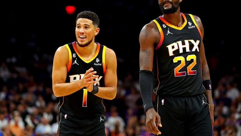 Oct 19, 2022; Phoenix, Arizona, USA; Phoenix Suns guard Devin Booker (1) and center Deandre Ayton (22) reacts during the fourth quarter against the Dallas Mavericks at Footprint Center. Mandatory Credit: Mark J. Rebilas-USA TODAY Sports