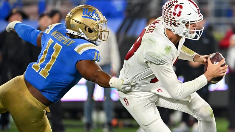 Oct 29, 2022; Pasadena, California, USA; Stanford Cardinal quarterback Tanner McKee (18) is pressured by UCLA Bruins defensive lineman Gabriel Murphy (11) in the second half at the Rose Bowl. Mandatory Credit: Jayne Kamin-Oncea-USA TODAY Sports