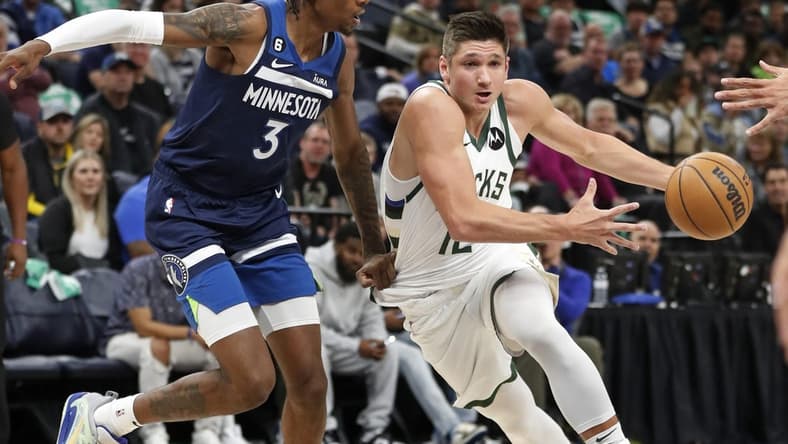 Nov 4, 2022; Minneapolis, Minnesota, USA; Milwaukee Bucks forward Grayson Allen (12) brings the ball around Minnesota Timberwolves forward Jaden McDaniels (3) in the first quarter at Target Center. Mandatory Credit: Bruce Kluckhohn-USA TODAY Sports