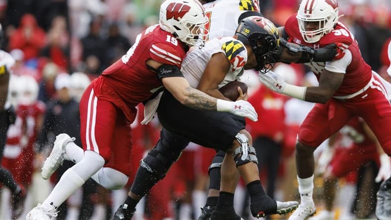 Nov 5, 2022; Madison, Wisconsin, USA;  Wisconsin Badgers linebacker Nick Herbig (19) tackles Maryland Terrapins quarterback Taulia Tagovailoa (3) during the second quarter at Camp Randall Stadium. Mandatory Credit: Jeff Hanisch-USA TODAY Sports