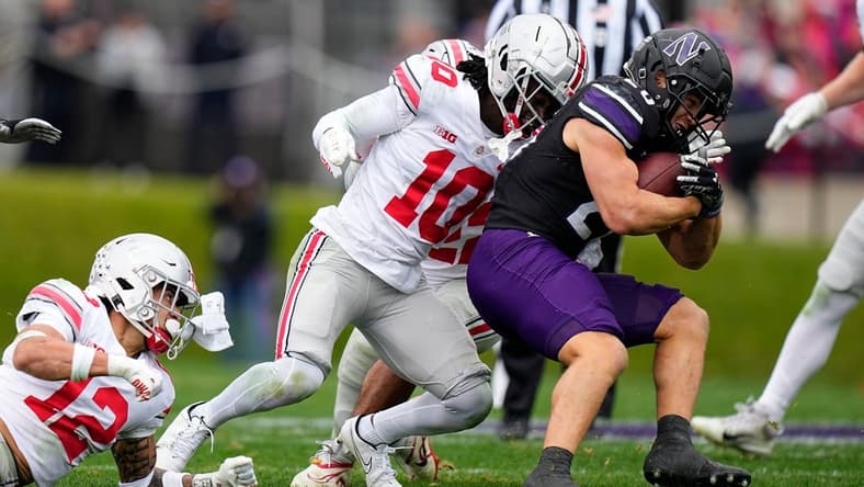 Nov 5, 2022; Evanston, Illinois, USA; Ohio State Buckeyes cornerback Denzel Burke (10) tackles Northwestern Wildcats running back Evan Hull (26) during the first half of the NCAA football game at Ryan Field. Mandatory Credit: Adam Cairns-The Columbus Dispatch

Ncaa Football Ohio State Buckeyes At Northwestern Wildcats