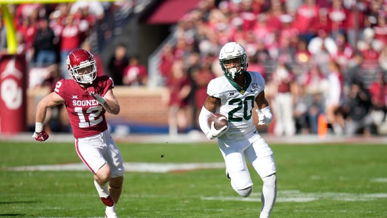 Nov 5, 2022; Norman, Oklahoma, USA; Baylor Bears safety Devin Lemear (20) returns an interception as Oklahoma Sooners wide receiver Drake Stoops (12) chases during the first half at Gaylord Family-Oklahoma Memorial Stadium. Mandatory Credit: Chris Jones-USA TODAY Sports