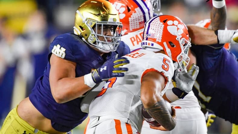 Nov 5, 2022; South Bend, Indiana, USA; Clemson Tigers quarterback DJ Uiagalelei (5) is sacked by Notre Dame Fighting Irish defensive lineman Howard Cross III (56) in the second quarter at Notre Dame Stadium. Mandatory Credit: Matt Cashore-USA TODAY Sports