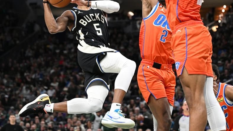 Nov 5, 2022; Milwaukee, Wisconsin, USA; Milwaukee Bucks guard Jevon Carter (5) drives to the basket against Oklahoma City Thunder guard Shai Gilgeous-Alexander (2) in the second quarter at Fiserv Forum. Mandatory Credit: Michael McLoone-USA TODAY Sports