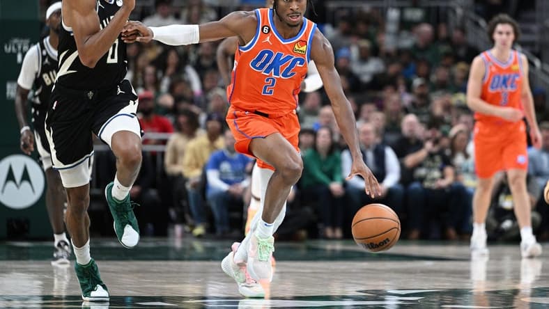Nov 5, 2022; Milwaukee, Wisconsin, USA; Oklahoma City Thunder guard Shai Gilgeous-Alexander (2) pushes the ball up the court against Milwaukee Bucks guard MarJon Beauchamp (0) in the third quarter at Fiserv Forum. Mandatory Credit: Michael McLoone-USA TODAY Sports