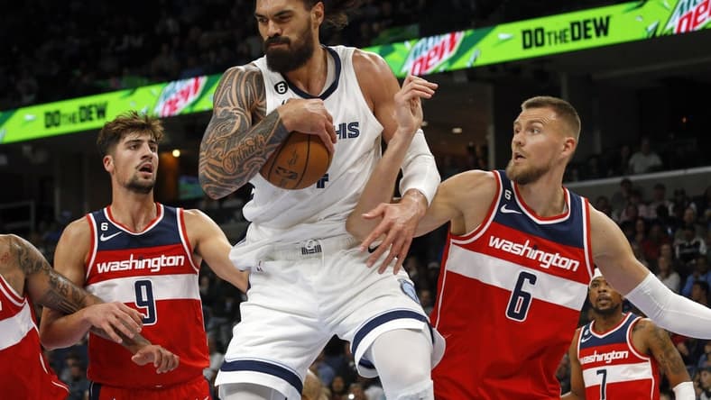 Nov 6, 2022; Memphis, Tennessee, USA; Memphis Grizzlies center Steven Adams (4) collects a rebound over Washington Wizards forward Deni Avdija (9) and Washington Wizards center Kristaps Porzingis (6) during the second quarter at FedExForum. Mandatory Credit: Petre Thomas-USA TODAY Sports