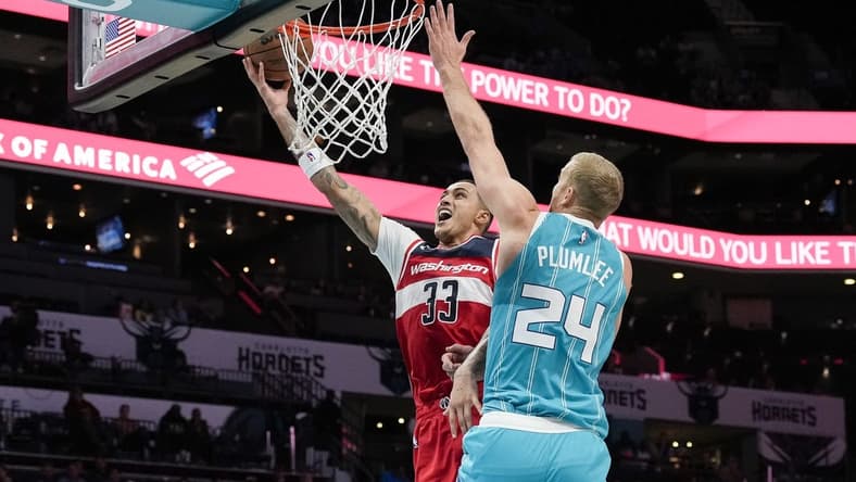 Nov 7, 2022; Charlotte, North Carolina, USA; Washington Wizards forward Kyle Kuzma (33) goes to the basket defended by Charlotte Hornets center Mason Plumlee (24) during the second half at Spectrum Center. Mandatory Credit: Jim Dedmon-USA TODAY Sports
