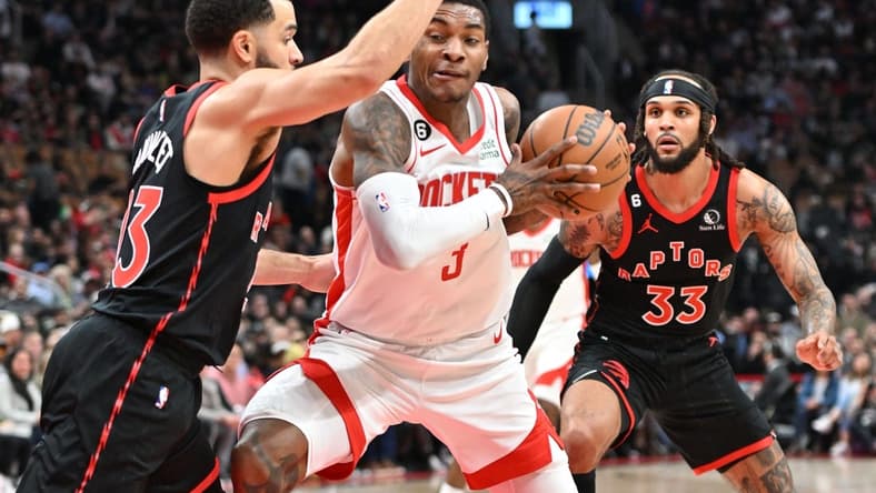 Nov 9, 2022; Toronto, Ontario, CAN; Houston Rockets guard Kevin Porter Jr. (3) tries to get past Toronto Raptors guards Fred VanVleet (23) and Gary Trent Jr. (33) in the first half at Scotiabank Arena. Mandatory Credit: Dan Hamilton-USA TODAY Sports