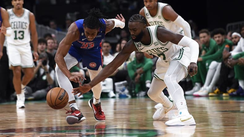 Nov 9, 2022; Boston, Massachusetts, USA; Detroit Pistons guard Jaden Ivey (23) and Boston Celtics guard Jaylen Brown (7) battle for a loose ball during the first half at TD Garden. Mandatory Credit: Bob DeChiara-USA TODAY Sports