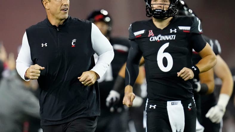 Cincinnati Bearcats head coach Luke Fickell and quarterback Ben Bryant (6) take the field for the first quarter of the NCAA American Athletic Conference game between the Cincinnati Bearcats and the East Carolina Pirates at Nippert Stadium in Cincinnati on Friday, Nov. 11, 2022.

East Carolina Pirates At Cincinnati Bearcats Football