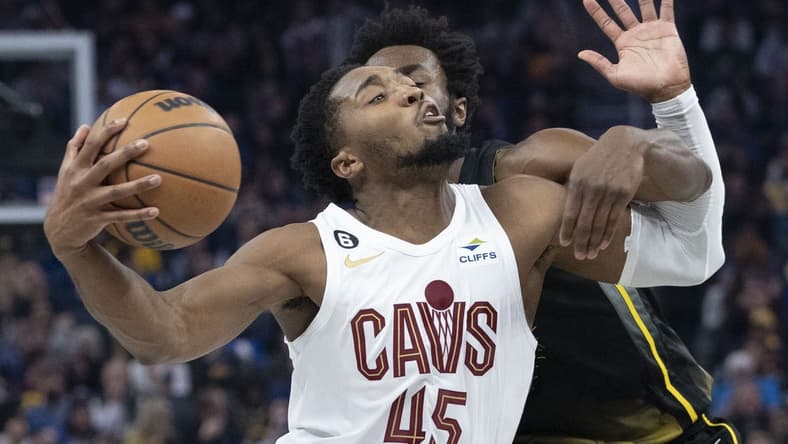 November 11, 2022; San Francisco, California, USA; Cleveland Cavaliers guard Donovan Mitchell (45) is fouled by Golden State Warriors forward Andrew Wiggins (22) during the second quarter at Chase Center. Mandatory Credit: Kyle Terada-USA TODAY Sports