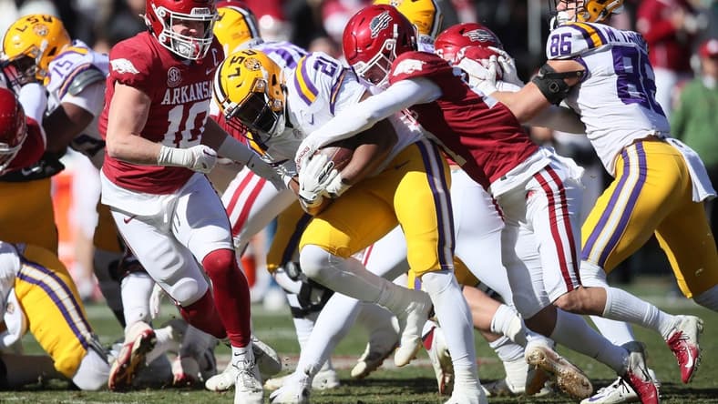 Nov 12, 2022; Fayetteville, Arkansas, USA; LSU Tigers running back Noah Cain (21) is tackled by Arkansas Razorbacks defensive back Hudson Clark (17) and linebacker Bumper Poole (10) during the second quarter at Donald W. Reynolds Razorback Stadium. Mandatory Credit: Nelson Chenault-USA TODAY Sports