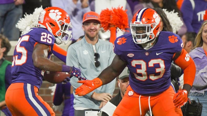 Nov 12, 2022; Clemson, South Carolina, USA; Clemson safety Jalyn Phillips (25) celebrates a fumble recovery defensive tackle Ruke Orhorhoro (33) playing Louisville during the third quarter at Memorial Stadium in Clemson, South Carolina Saturday, Nov. 12, 2022. Mandatory Credit: Ken Ruinard-USA TODAY Sports