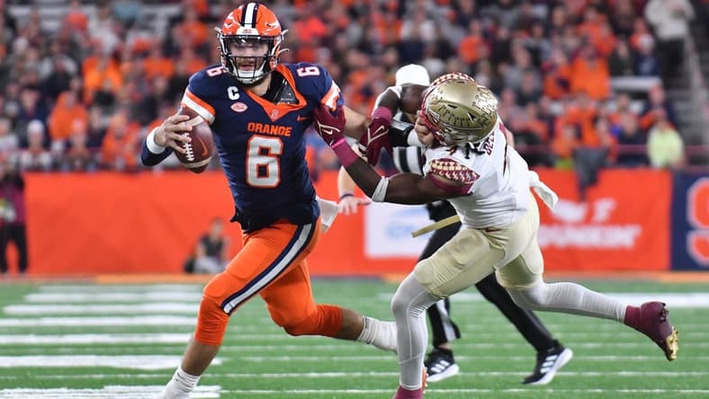 Nov 12, 2022; Syracuse, New York, USA; Syracuse Orange quarterback Garrett Shrader (6) tries to shake a tackle by Florida State Seminoles linebacker Kalen DeLoach (4) in the second quarter at JMA Wireless Dome. Mandatory Credit: Mark Konezny-USA TODAY Sports