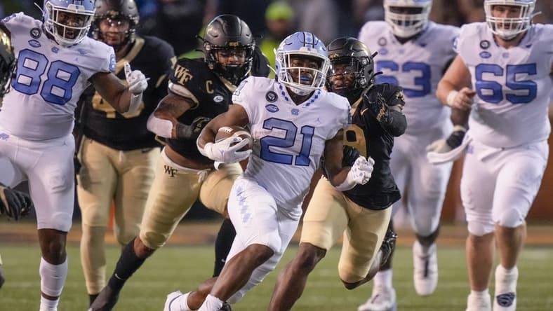 Nov 12, 2022; Winston-Salem, North Carolina, USA; North Carolina Tar Heels running back Elijah Green (21) outruns the Wake Forest Demon Deacons defense during the first half at Truist Field. Mandatory Credit: Jim Dedmon-USA TODAY Sports