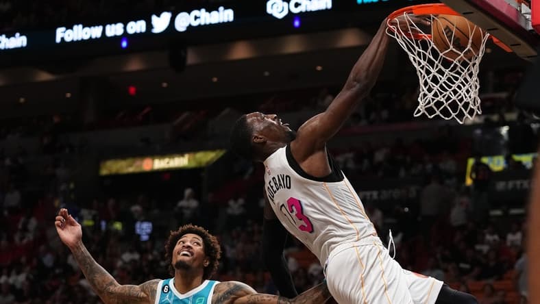 Nov 12, 2022; Miami, Florida, USA; Miami Heat center Bam Adebayo (13) dunks the ball over Charlotte Hornets guard Kelly Oubre Jr. (12) during the second half at FTX Arena. Mandatory Credit: Jasen Vinlove-USA TODAY Sports