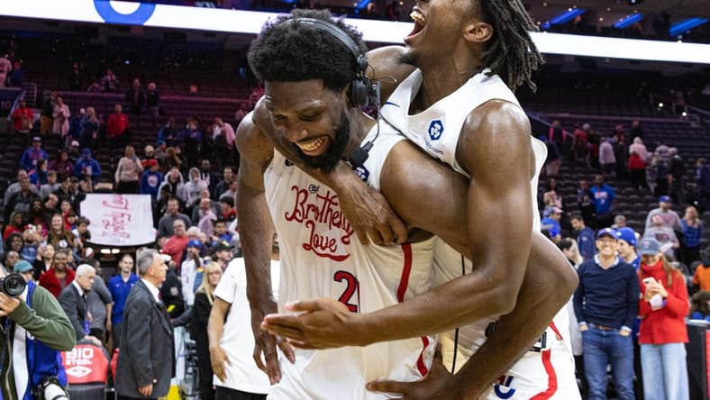 Nov 13, 2022; Philadelphia, Pennsylvania, USA; Philadelphia 76ers guard Tyrese Maxey (0) leaps onto center Joel Embiid (21) after Embiids 59 points in a victory against the Utah Jazz at Wells Fargo Center. Mandatory Credit: Bill Streicher-USA TODAY Sports