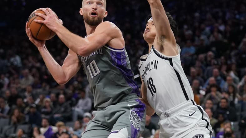 Nov 15, 2022; Sacramento, California, USA; Sacramento Kings forward Domantas Sabonis (10) holds onto the ball next to Brooklyn Nets guard Yuta Watanabe (18) in the third quarter at the Golden 1 Center. Mandatory Credit: Cary Edmondson-USA TODAY Sports
