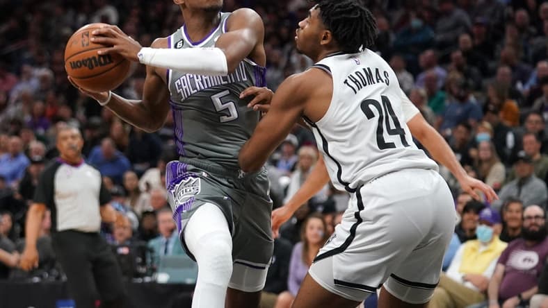 Nov 15, 2022; Sacramento, California, USA; Sacramento Kings guard De'Aaron Fox (5) drives to the hoop next to Brooklyn Nets guard Cam Thomas (24) in the third quarter at the Golden 1 Center. Mandatory Credit: Cary Edmondson-USA TODAY Sports
