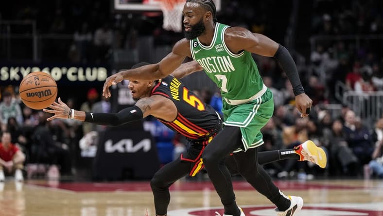 Nov 16, 2022; Atlanta, Georgia, USA; Atlanta Hawks guard Dejounte Murray (5) deflects the ball away from Boston Celtics guard Jaylen Brown (7) during the first half at State Farm Arena. Mandatory Credit: Dale Zanine-USA TODAY Sports