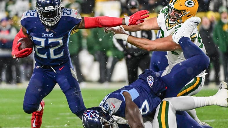 Nov 17, 2022; Green Bay, Wisconsin, USA; Tennessee Titans running back Derrick Henry (22) attempts to break a tackle by Green Bay Packers defensive end Dean Lowry (94) in the first quarter at Lambeau Field. Mandatory Credit: Benny Sieu-USA TODAY Sports